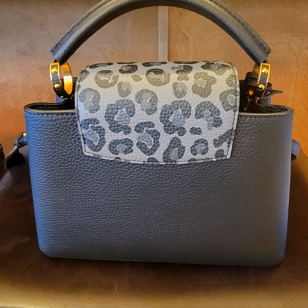 Capucines BB shoulder straps bag. Black with leather animal prints trim.
